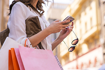 Lady with shopping bags looking at her cellphone