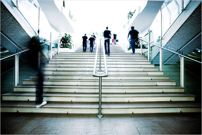 People walking up steps in a modern building