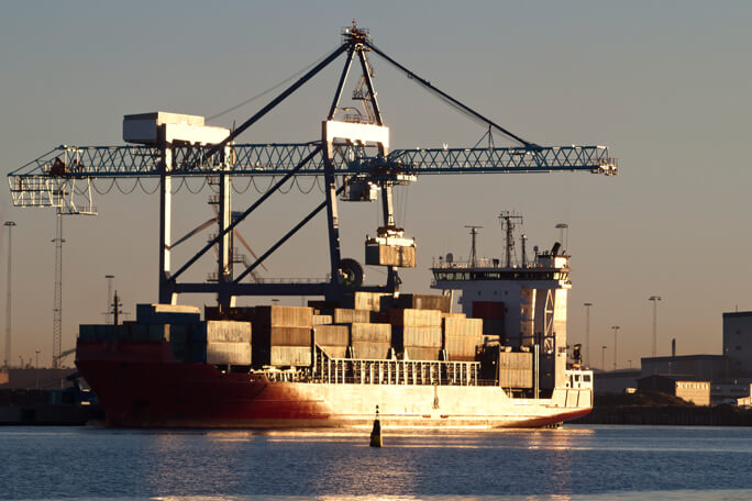 Crane lifting a container from a docked container ship